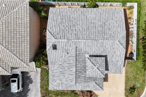 9-Apr 16 2026 01_59pm-VHKC - Monarch Roofing Aerial view of two neighboring houses with gray tiled roofs; a driveway with a white SUV on the left side.